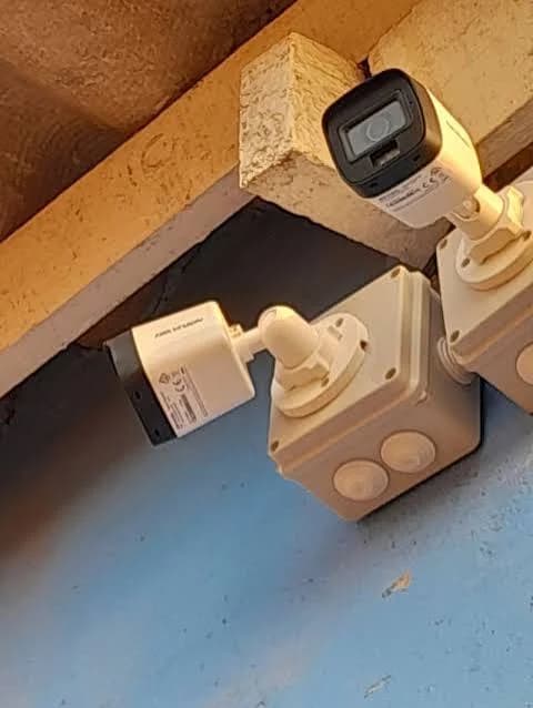 Two CCTV cameras installed beneath the roof line of a property