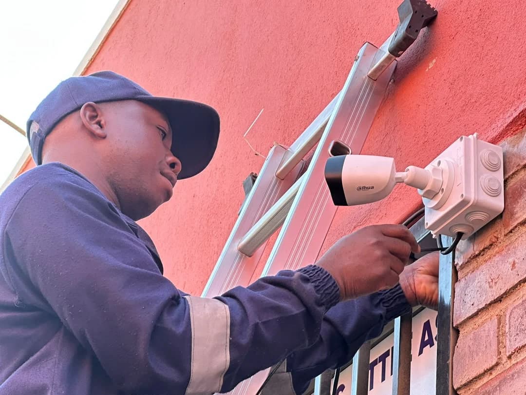 Wikilax Tech Solutions technician installing an exterior camera at a business property